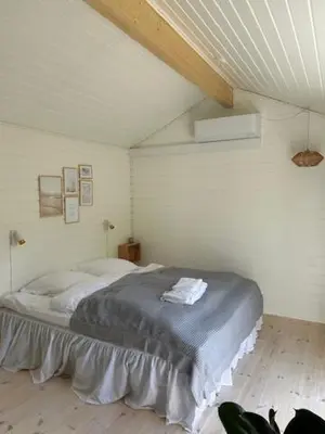 a bedroom with a large bed in a attic at Rødhus Gl. Skole B&B in Pandrup