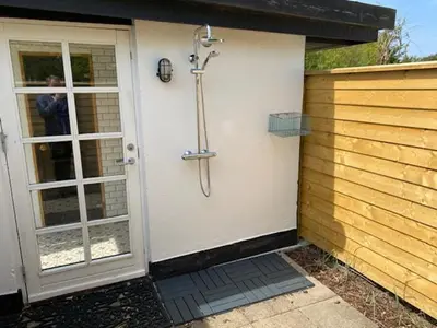 a shower in the side of a house at Rødhus Gl. Skole B&B in Pandrup