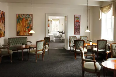 a waiting room with tables and chairs and a room with a dining room at Aars Hotel in Års