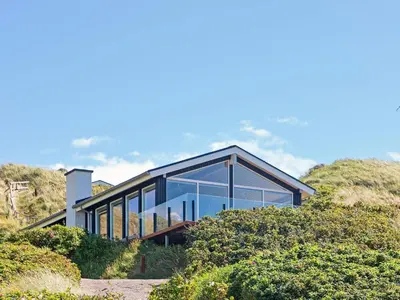 a glass house on the side of a hill at 6 person holiday home in Løkken in Løkken