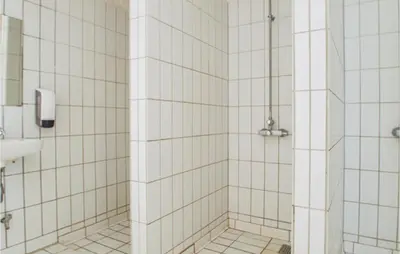 a bathroom with a shower with white tiled walls at Feriehotel Tranum Klit in Brovst