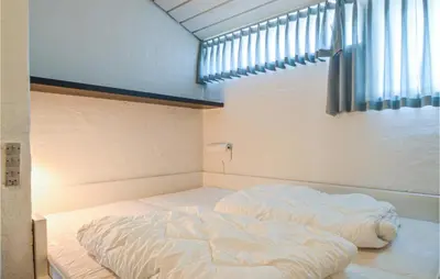 a large bed in a room with a window at Feriehotel Tranum Klit in Brovst