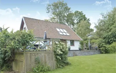 a house with a wooden fence in a yard at Fjordens Perle in Farsø