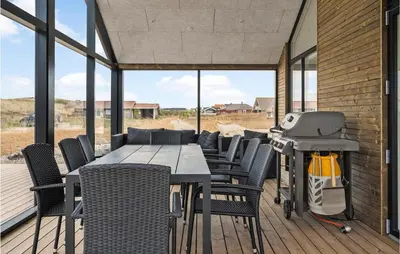 a patio with a table and chairs and a grill at Nice Home In Harboøre With Sauna in Harboør