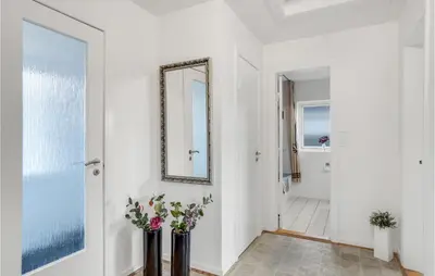a hallway with a mirror and two vases with flowers at 2 Bedroom Lovely Home In Thisted in Thisted