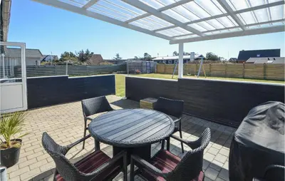 a patio with a table and chairs on a roof at 2 Bedroom Lovely Home In Thisted in Thisted
