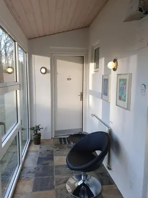 a room with a black chair in front of a door at Bente's Guesthouse in Holstebro