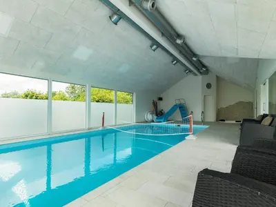 a swimming pool with blue water in a building at 15 person holiday home in Højslev in Højslev