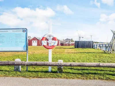 a sign sitting next to a bench in a field at 15 person holiday home in Højslev in Højslev