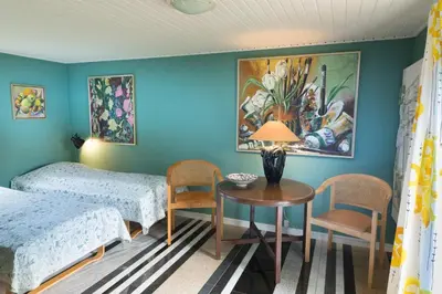 a bedroom with two beds and a table and chairs at Anne Just's Havehotel in Blokhus