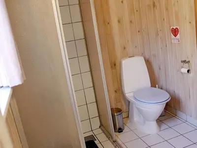 a bathroom with a white toilet in a room at Secluded Forest Retreat at Gjol-By Traum in Åbybro