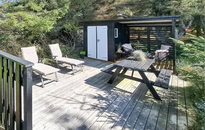 a wooden deck with a picnic table and a shed at Nice Home In Thisted With Sauna in Thisted