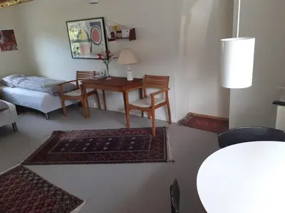 a living room with a table and chairs and a couch at Brovst bed and breakfast in Brovst