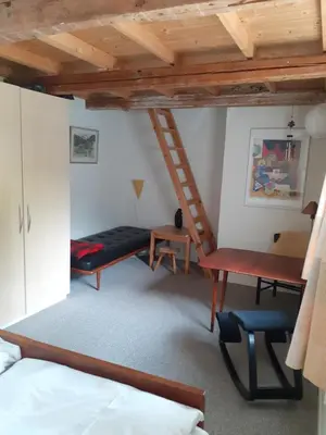 a room with a bed and a desk and a ladder at Brovst bed and breakfast in Brovst