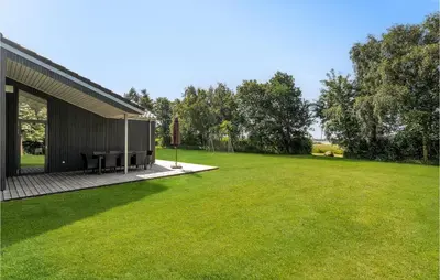a house with a large lawn next to a building at 4 Bedroom Cozy Home In Spøttrup in Spottrup