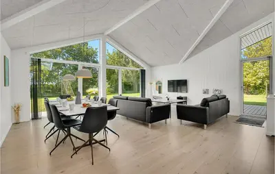 a living room with a table and chairs at 4 Bedroom Cozy Home In Spøttrup in Spottrup