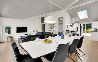 a dining room and living room with a white table and chairs at 4 Bedroom Cozy Home In Spøttrup in Spottrup