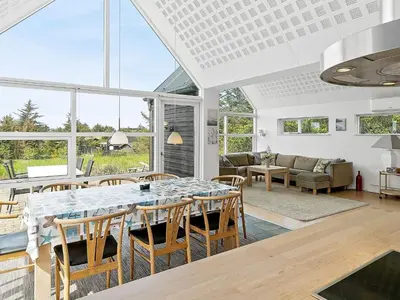 a living room with a large table and chairs at 6 person holiday home in Blokhus in Blokhus
