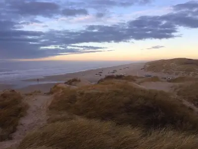 a view of a beach with cars parked on it at 6 person holiday home in Blokhus in Blokhus
