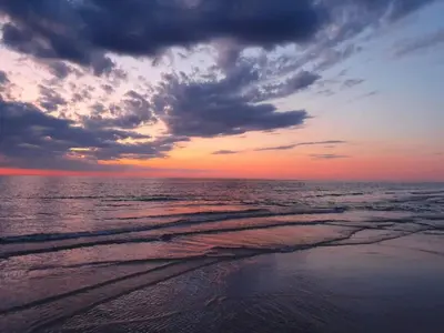 a sunset over the ocean with a cloudy at 6 person holiday home in Blokhus in Blokhus