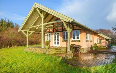 a house with awning and a table in the yard at Cozy Home In Thyholm With Wifi in Thyholm