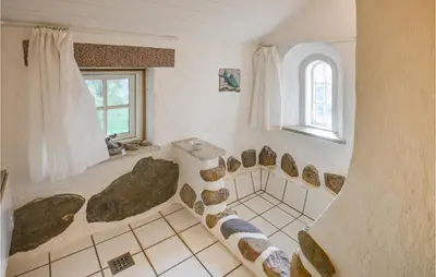 a bathroom with a shower with rocks on the floor at Cozy Home In Thyholm With Wifi in Thyholm