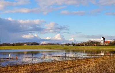 a pond of water with a barn in the background at Cozy Home In Thyholm With Wifi in Thyholm