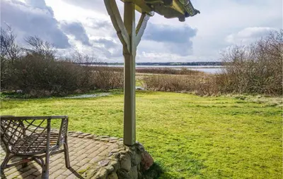 a bench sitting on a brick patio with a pole at Cozy Home In Thyholm With Wifi in Thyholm