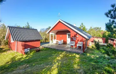 a red barn with a deck and a house at Nice Home In Hurup Thy in Sønder Ydby