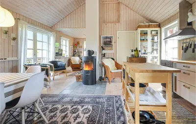 a kitchen and living room with a table and a stove at Nice Home In Hurup Thy in Sønder Ydby
