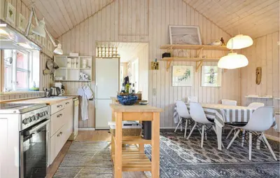 a kitchen with a table and chairs and a table and a kitchen with a table at Nice Home In Hurup Thy in Sønder Ydby