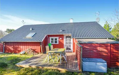 a red shed with a table on a deck at Nice Home In Hurup Thy in Sønder Ydby