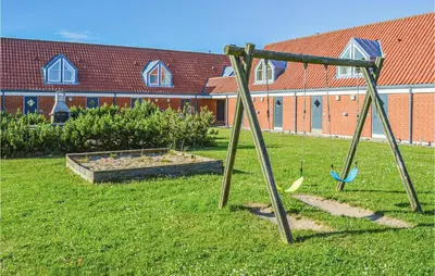 a playground with swings in a yard with a building at Lovely Apartment In Lemvig With Kitchen in Lemvig