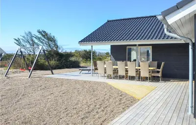 a patio with chairs and a table and a swing at Amazing Home In Thisted With Sauna in Thisted