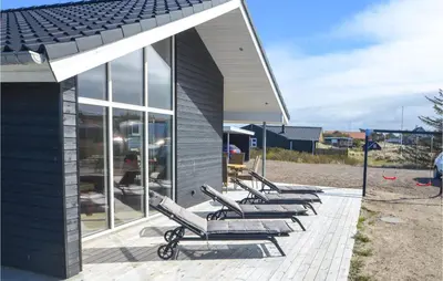 a row of lounge chairs sitting next to a building at Amazing Home In Thisted With Sauna in Thisted