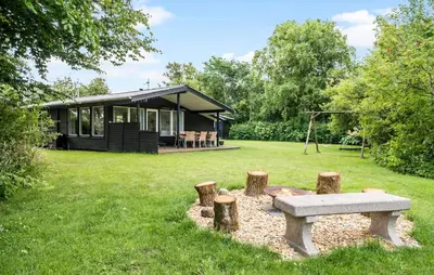 a log cabin with a bench in the yard at Cozy Home In Hjerm With Kitchen in Hjerm