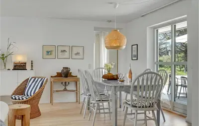 a dining room with a table and chairs at 4 Bedroom Gorgeous Home In Blokhus in Blokhus