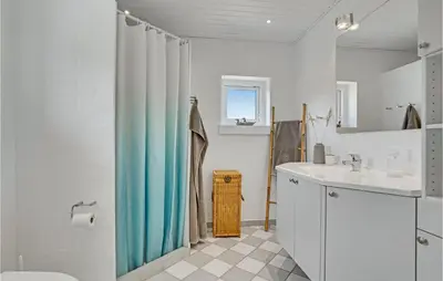 a bathroom with a shower curtain and a sink at 4 Bedroom Gorgeous Home In Blokhus in Blokhus