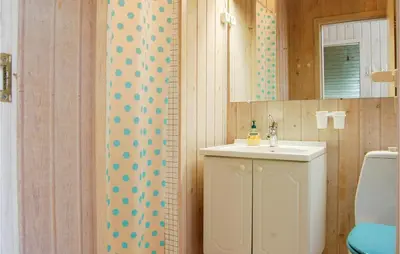 a bathroom with a sink and a toilet and a mirror at Villa Mormor in Løkken