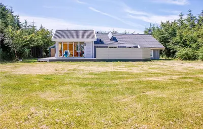 a small house in a field with a yard at Villa Mormor in Løkken