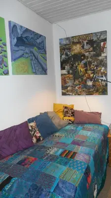a bedroom with a bed with a colorful quilt on it at Enkeltværelse in Vestervig