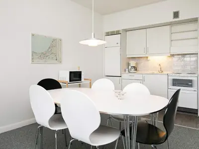 a white dining room with a white table and chairs at 6 person holiday home on a holiday park in Blokhus in Blokhus