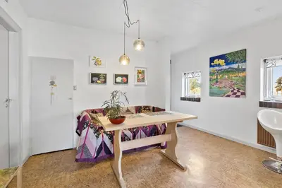 a room with a table with a potted plant on it at Logi i hus med kunst og have in Vestervig