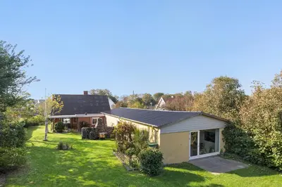a small house with a garden and a backyard at Logi i hus med kunst og have in Vestervig