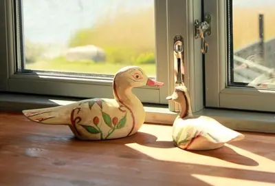 two rubber ducks sitting on the floor near a window at Skibstedgaard in Hurup