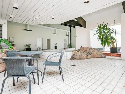 a patio with chairs and a table and a rock formation at 6 person holiday home in Brovst in Brovst