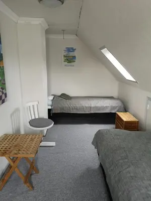 a room with two beds and a table and a chair at Værelse som dobbelt el. enkelt, Engen 5, 7770 Vestervig in Vestervig