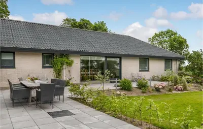 a patio with a table and chairs in front of a house at Awesome Home In Holstebro With Kitchen in Holstebro