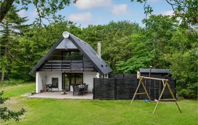 a small house with a gambrel roof with a playground at Cozy Home In Øster Assels With Sauna in Øster Assels