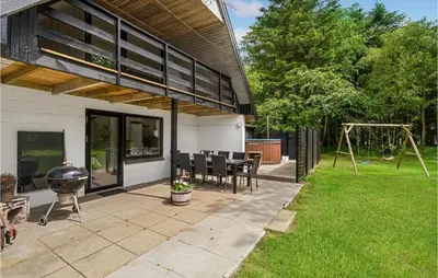 a backyard with a grill and a playground at Cozy Home In Øster Assels With Sauna in Øster Assels
